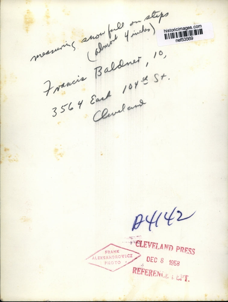 Load image into Gallery viewer, 1958 Press Photo Francis Baldnet measuring snowfall on steps - nef53569
