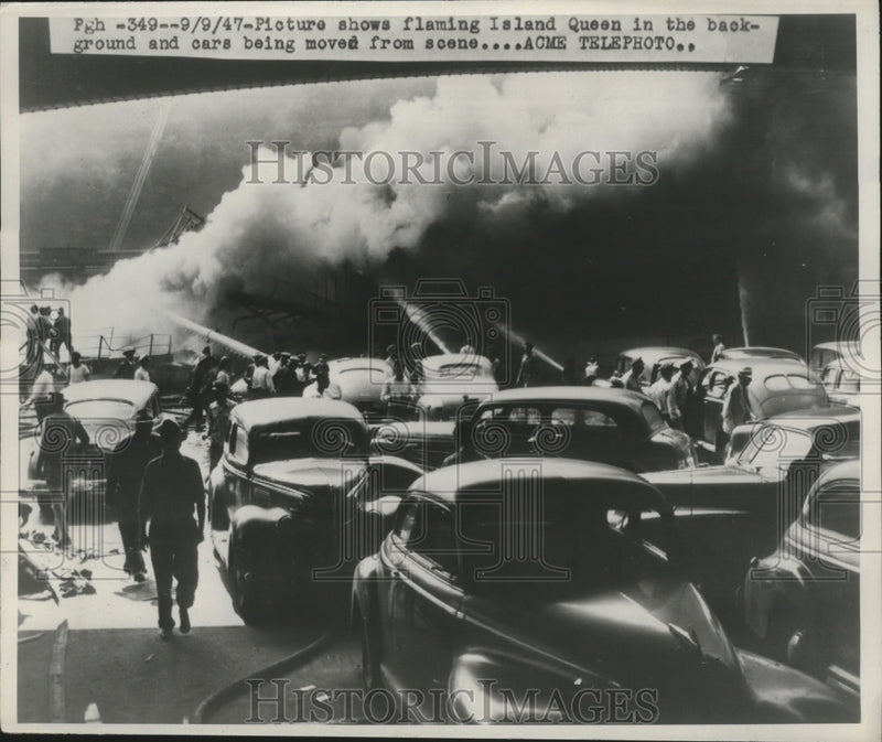 Load image into Gallery viewer, 1947 Press Photo Flaming Island Queen &amp; Cars Being Moved Away From Boat Diasater
