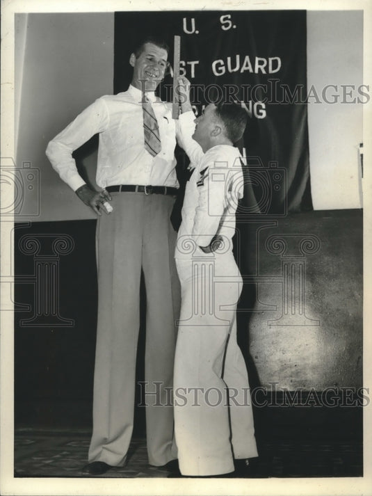 1943 Press Photo John Laxton looks up to Coast guardsman Joseph O'Connell