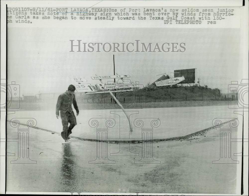 1961 Press Photo Young man along street near sign damaged by hurricane, Texas- Historic Images