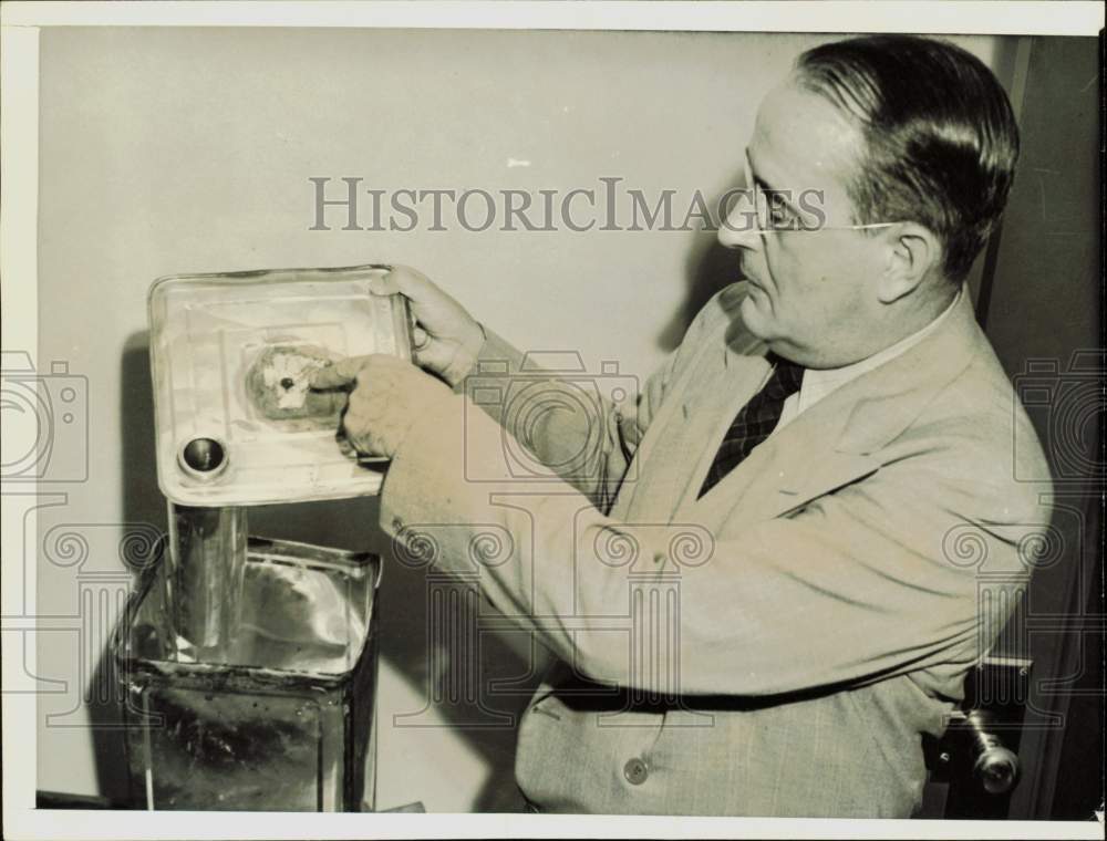 1941 Press Photo Ralph Herrick with can of alcohol seized in raid, Chicago, IL- Historic Images