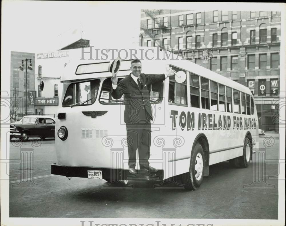 1959 Press Photo Tom Ireland clinging onto front of parked campaign bus- Historic Images