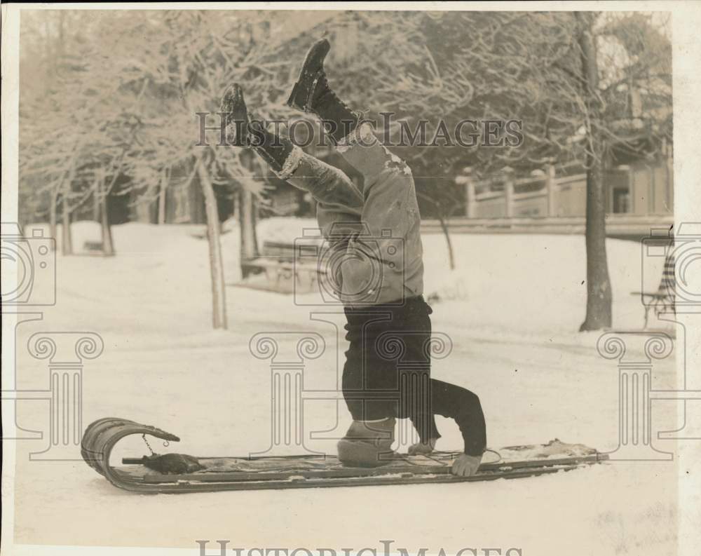 1929 Press Photo Ted Raymond rides a toboggan on his head in Quebec - nei19467- Historic Images