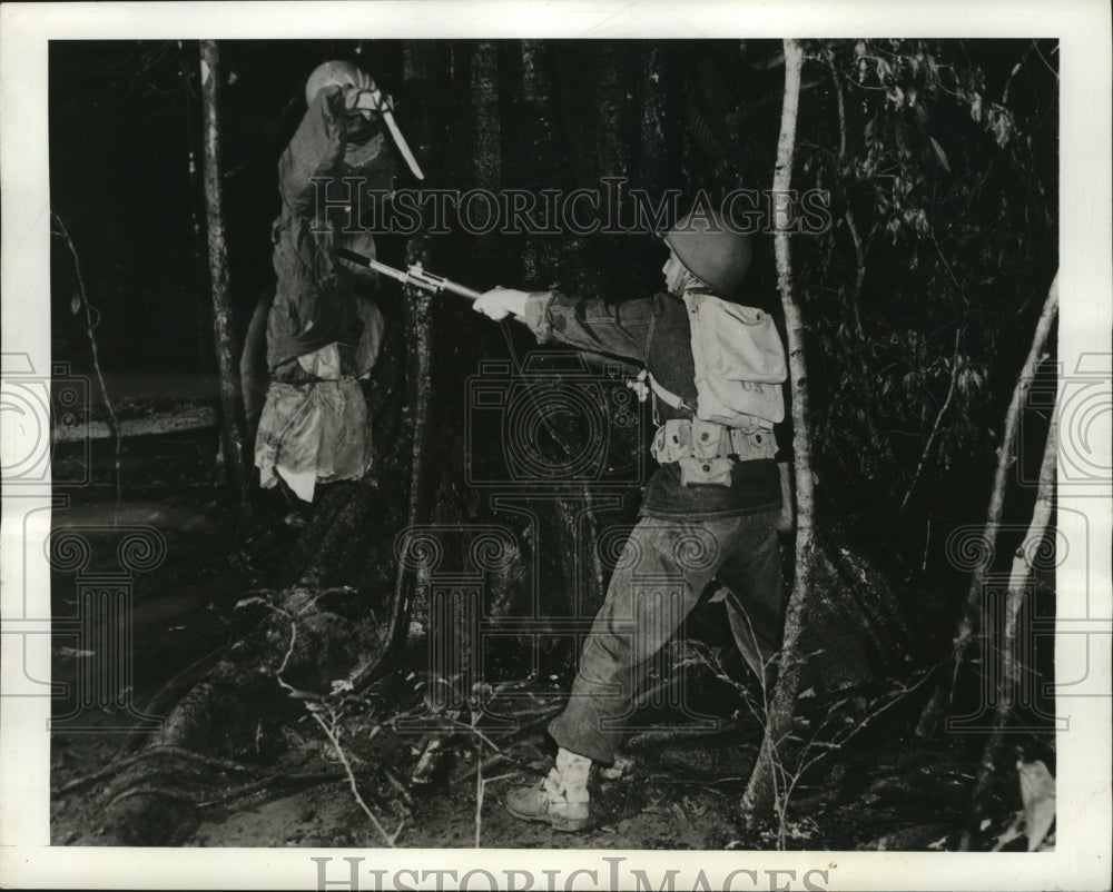 1943 Press Photo Soldier stabs Japanese dummy with bayonet during training