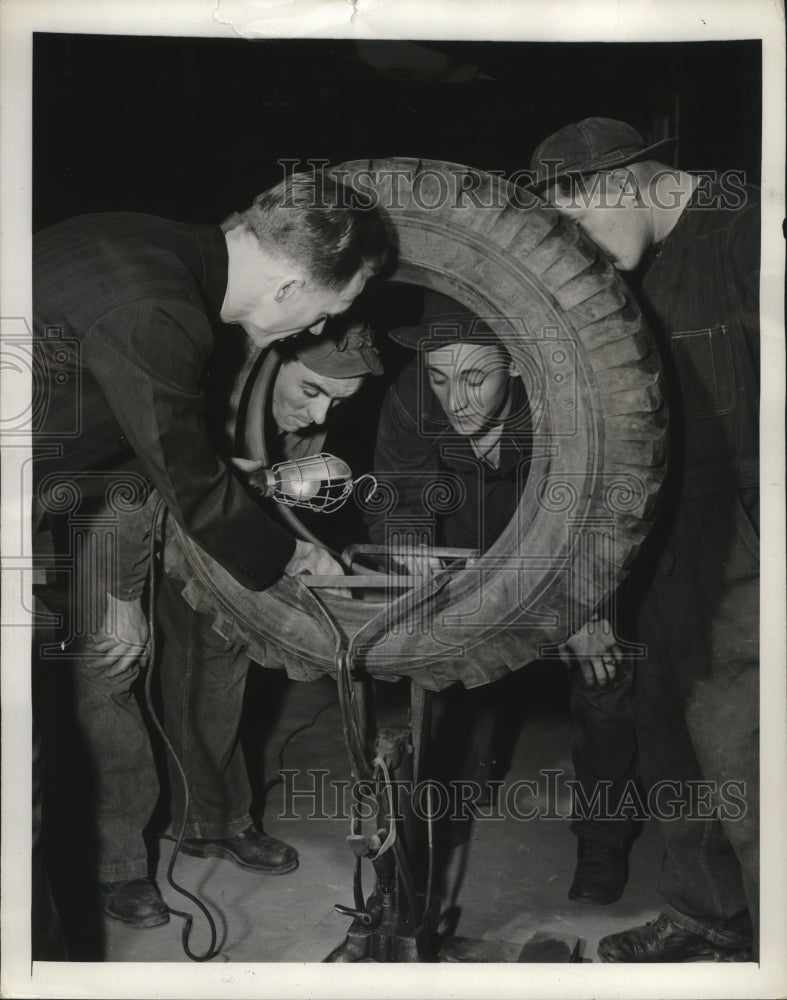 1942 Press Photo Tire engineer Kirk Owens inspects Army tires to conserve rubber