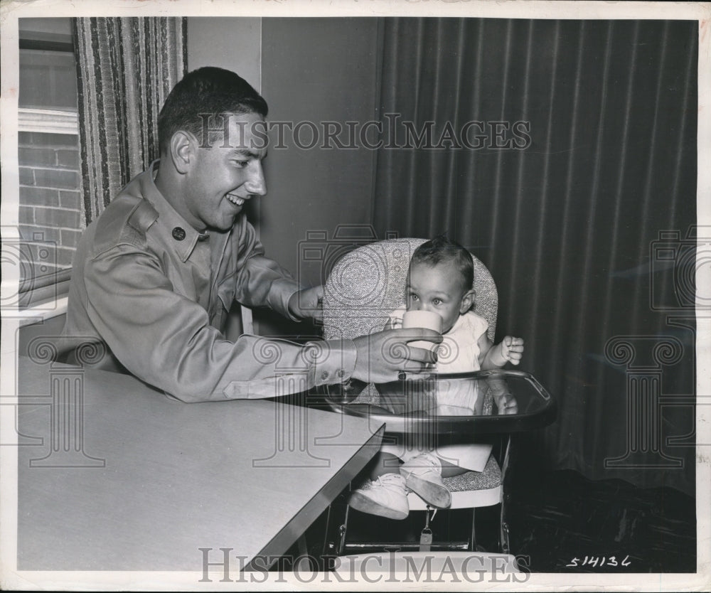 1957 Press Photo Pvt. George E. Schumacher babysitting Sarah Ann Wharton