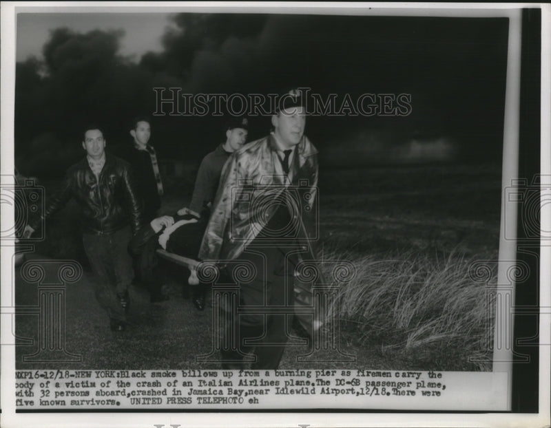 Load image into Gallery viewer, 1955 Press Photo Rescuers carry a victim's body out of the crashed Italian plane
