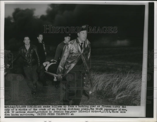 1955 Press Photo Rescuers carry a victim's body out of the crashed Italian plane