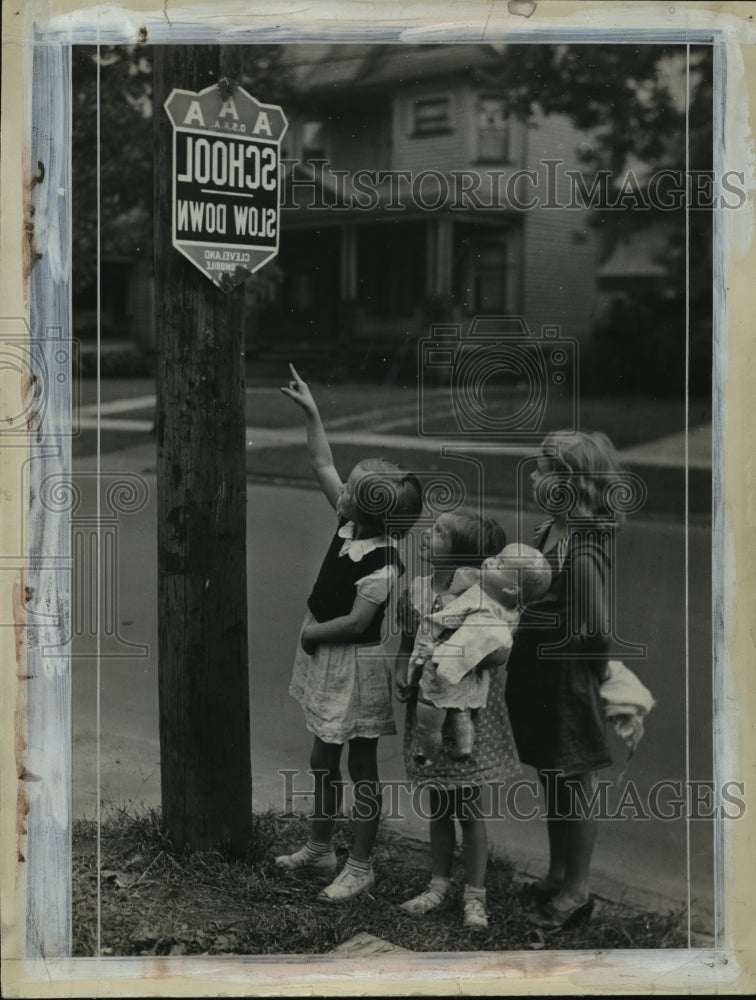 Load image into Gallery viewer, 1936 Press Photo Children Looking At School Sign, While Holding A Baby Doll
