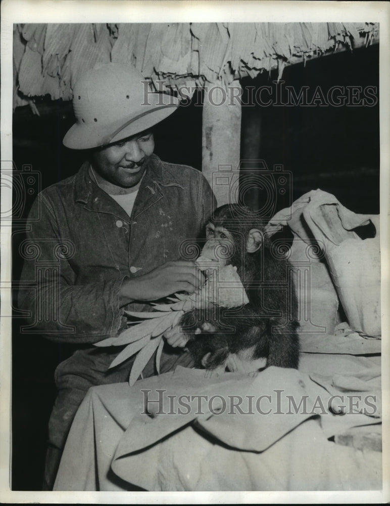 1942 Press Photo Pfc Napoleon Taylor Feeds Mascot Kudabu Pineapple in Liberia- Historic Images