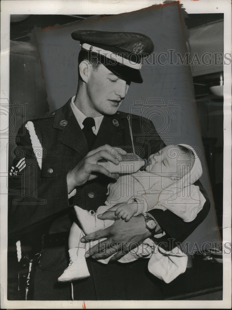Load image into Gallery viewer, 1952 Press Photo Airman Charles T. Pinkman feeds son of Felix Harmuth at Orly
