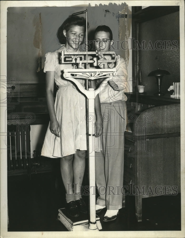 Load image into Gallery viewer, 1941 Press Photo Dr. Ralph Fried measures Lillian Johnson of Olmsted
