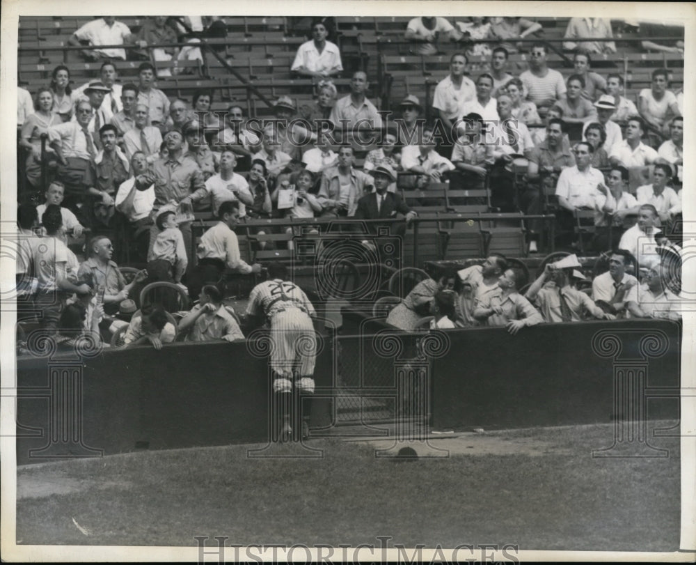 1943 Press Photo Fans duck as Yankee catcher Rollie Hemsley leans into boxes- Historic Images