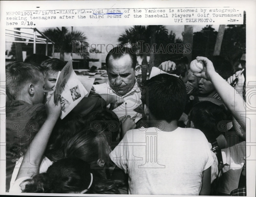 1961 Press Photo Yankees Yogi Bera signs autographs for fans in Miami Florida- Historic Images