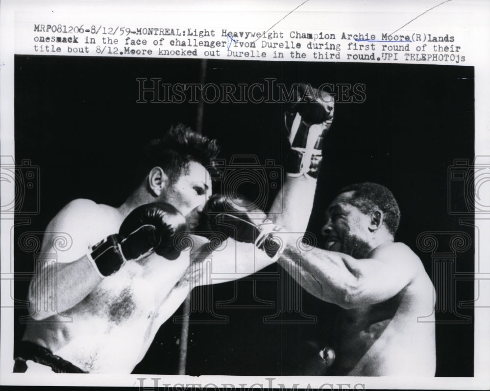 1959 Press Photo Champ Archie Moore jabs challenger Yvon Durelle in Montreal- Historic Images