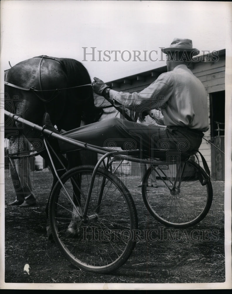 1950 Press Photo Driver Red Stine demonstrates sulky racing position - nes49342- Historic Images