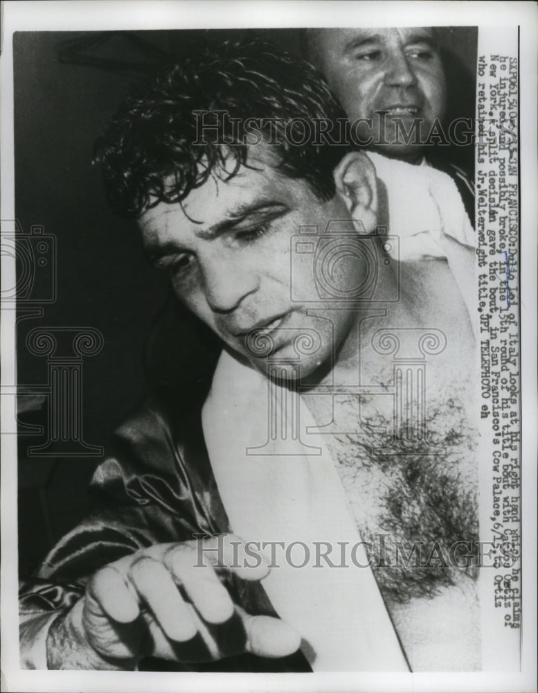 1960 Press Photo Boxer Dulio Lei looks at injured right hand after match- Historic Images