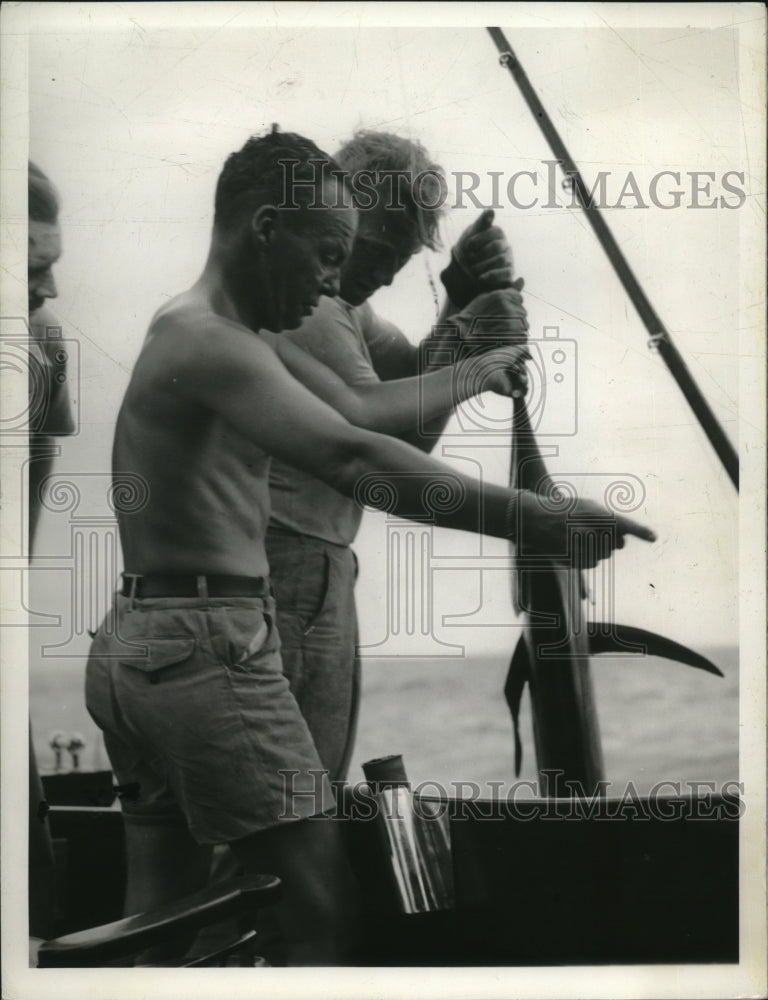 1939 Press Photo Bob Stuart pulls in and tags a sailfish near Miami Beach, FL- Historic Images