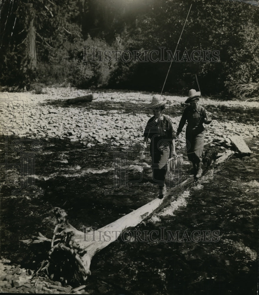 1923 Press Photo Two women cross a creek on a log while fishing - net24912- Historic Images