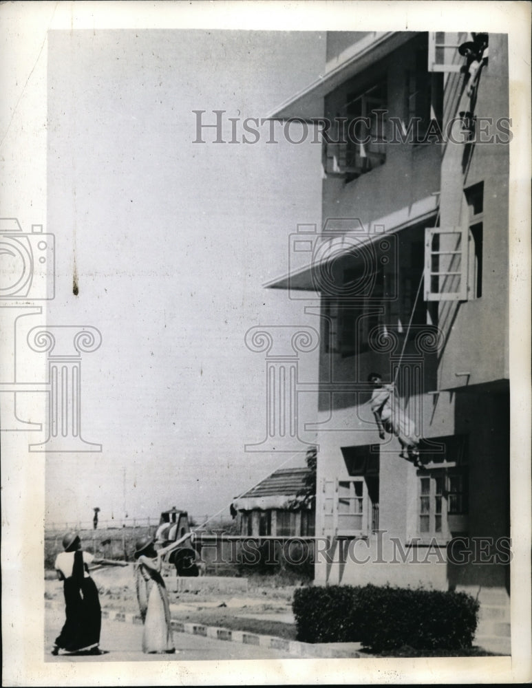 Load image into Gallery viewer, 1942 Press Photo Indians prepare for emergencies lowers down a girl from window
