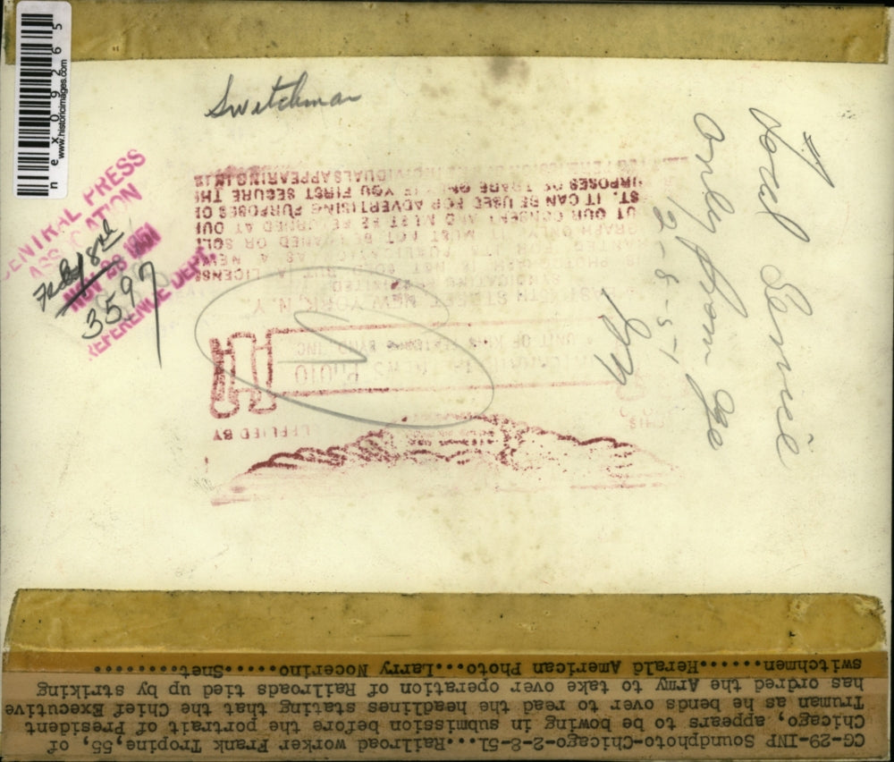 1951 Press Photo Frank Tropine bows in submission before president truman sign