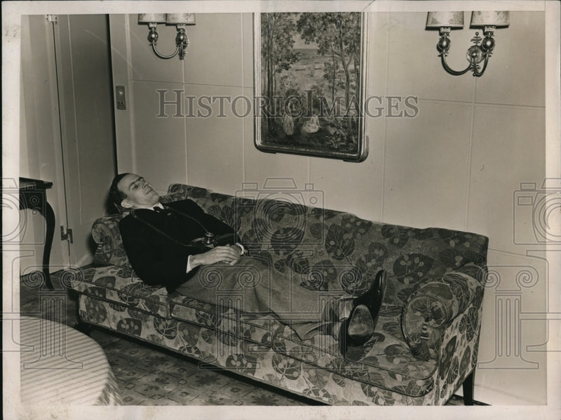 Load image into Gallery viewer, 1937 Press Photo Dave McLane a camerman on a sofa aboard a ship
