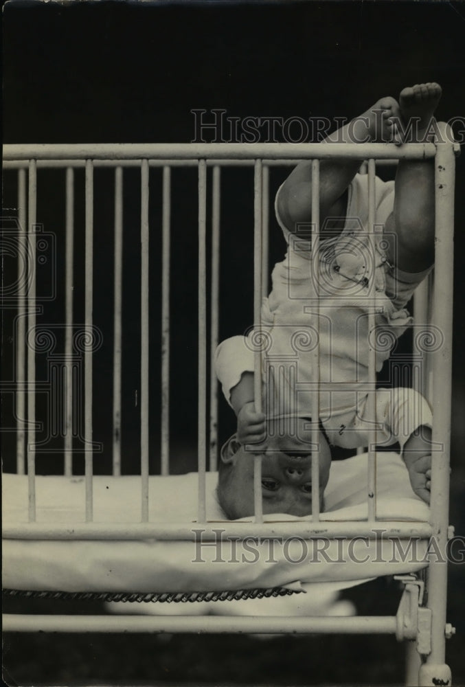 1924 Press Photo A baby stands on its head in a crib