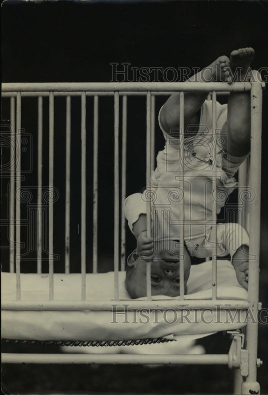 1924 Press Photo A baby stands on its head in a crib