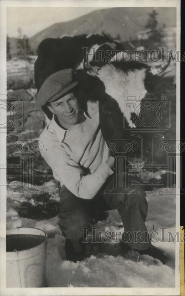 1933 Press Photo Rolf Larson milks cow for college expenses