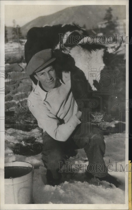 1933 Press Photo Rolf Larson milks cow for college expenses