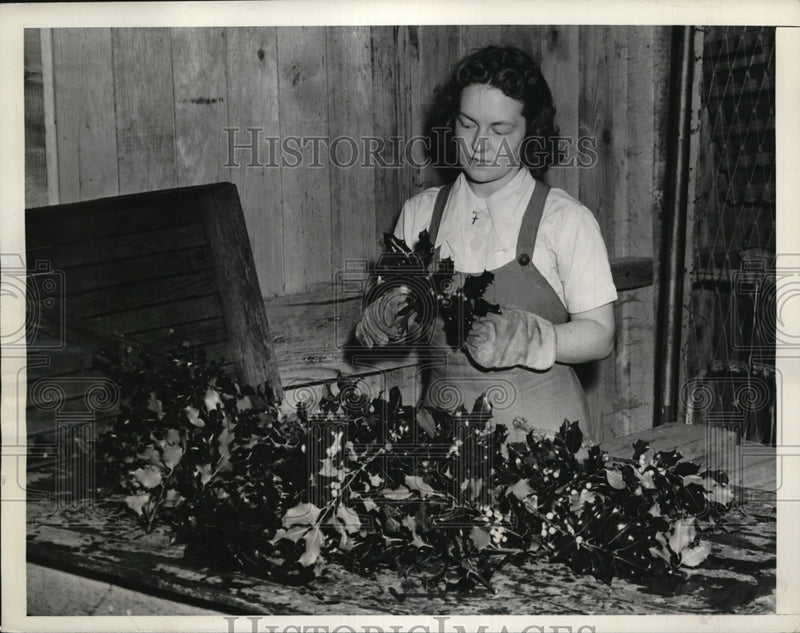 Load image into Gallery viewer, 1939 Press Photo Girl sorting through holly.
