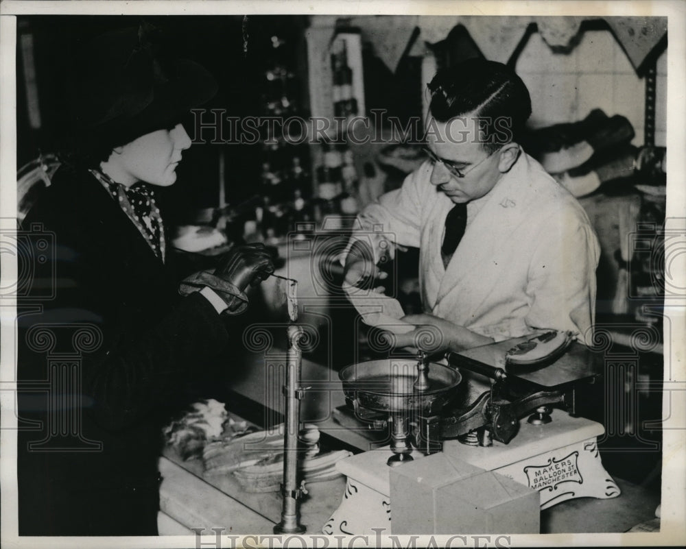 1940 Press Photo London Shop Clerk Cuts Coupons From Housewife Ration Book