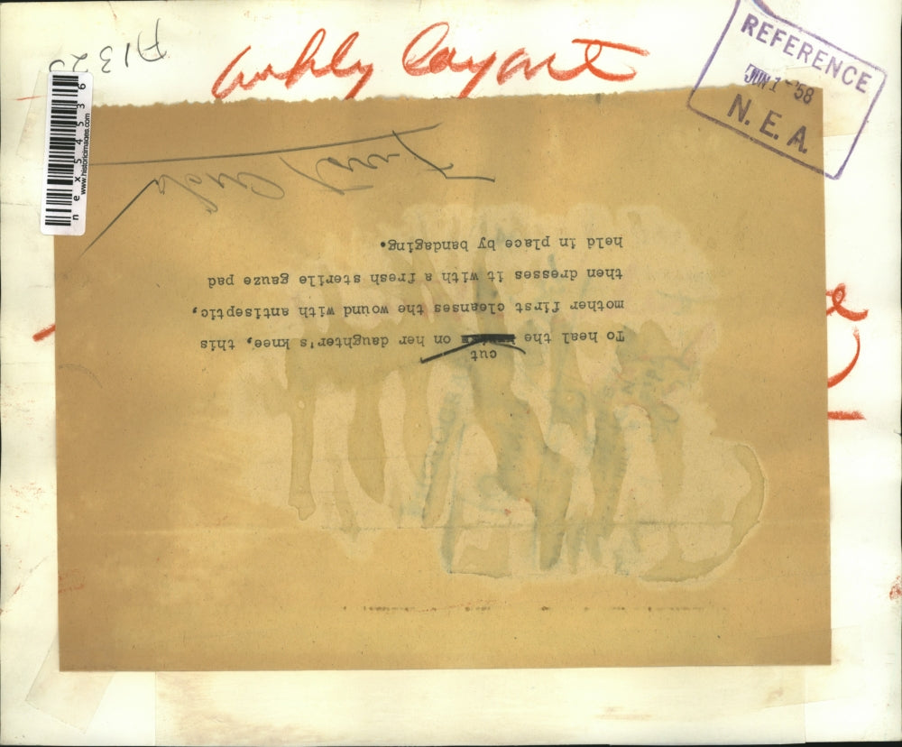 1958 Press Photo Woman bandages daughters knee with sterile gauze