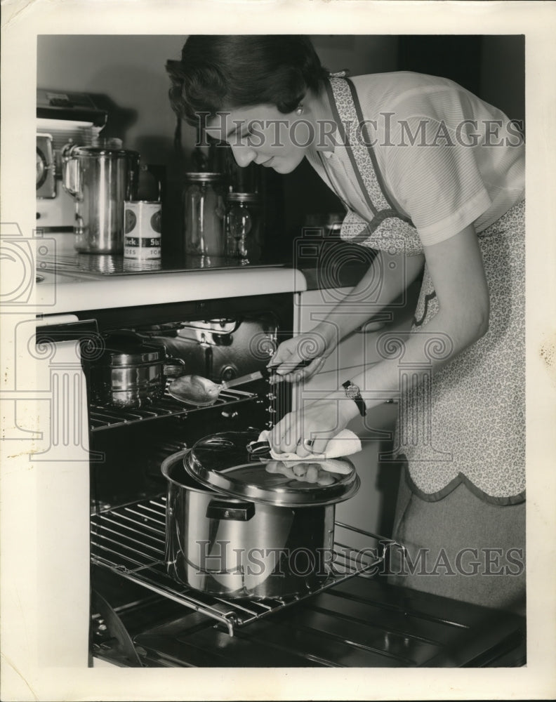 1955 Press Photo Housewife cooking in her home's oven