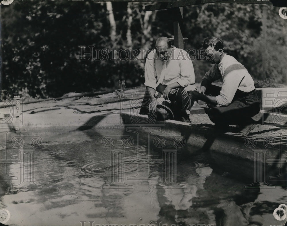 1923 Press Photo Men feeding fish in a nursery pond