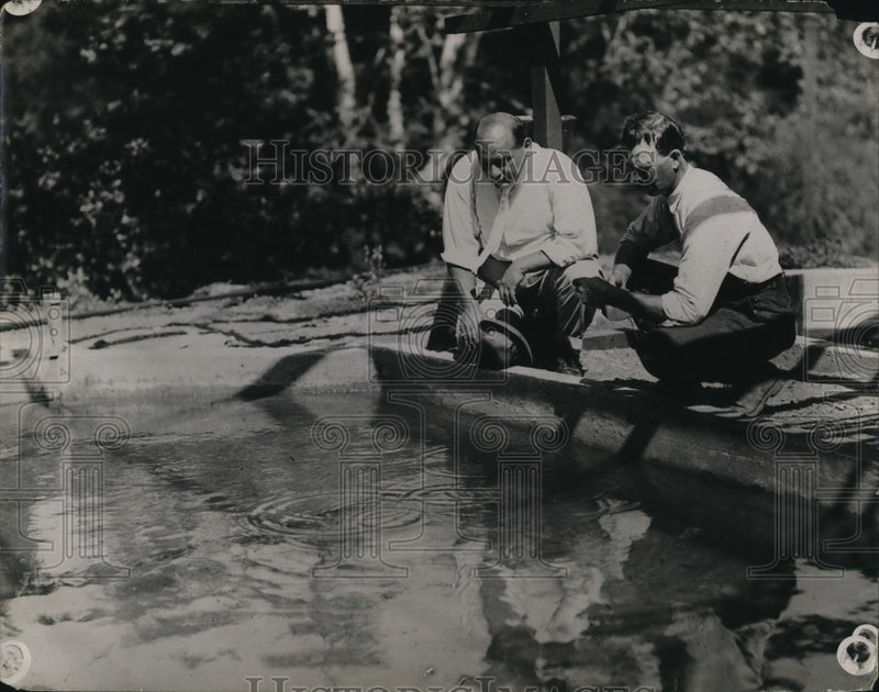 Load image into Gallery viewer, 1923 Press Photo Men feeding fish in a nursery pond
