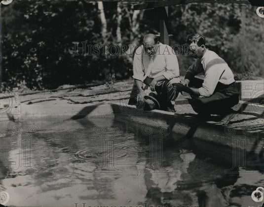 1923 Press Photo Men feeding fish in a nursery pond