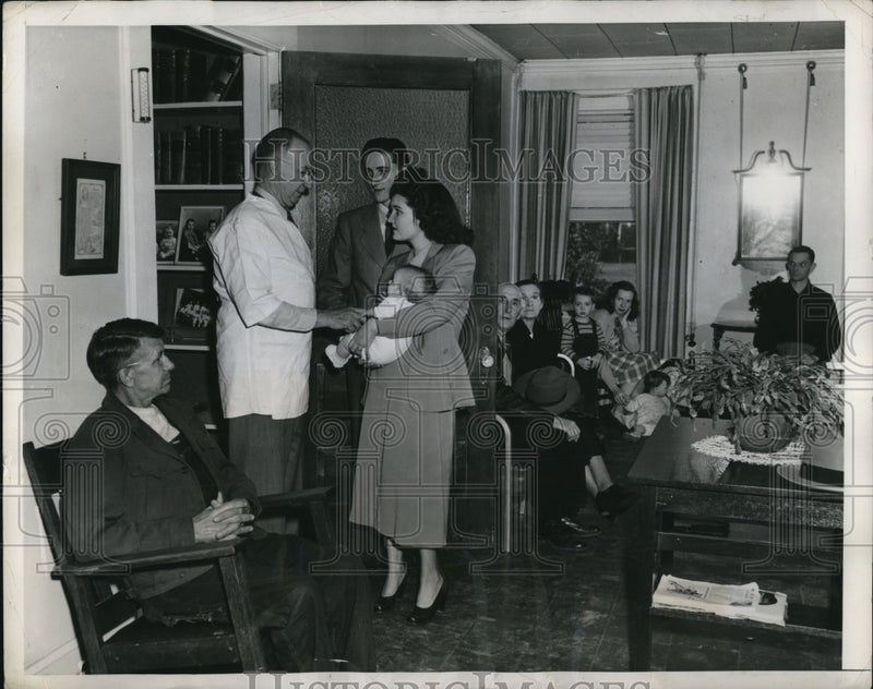 Load image into Gallery viewer, 1949 Press Photo Dr Wm Pressly &amp; young parents at his clinic
