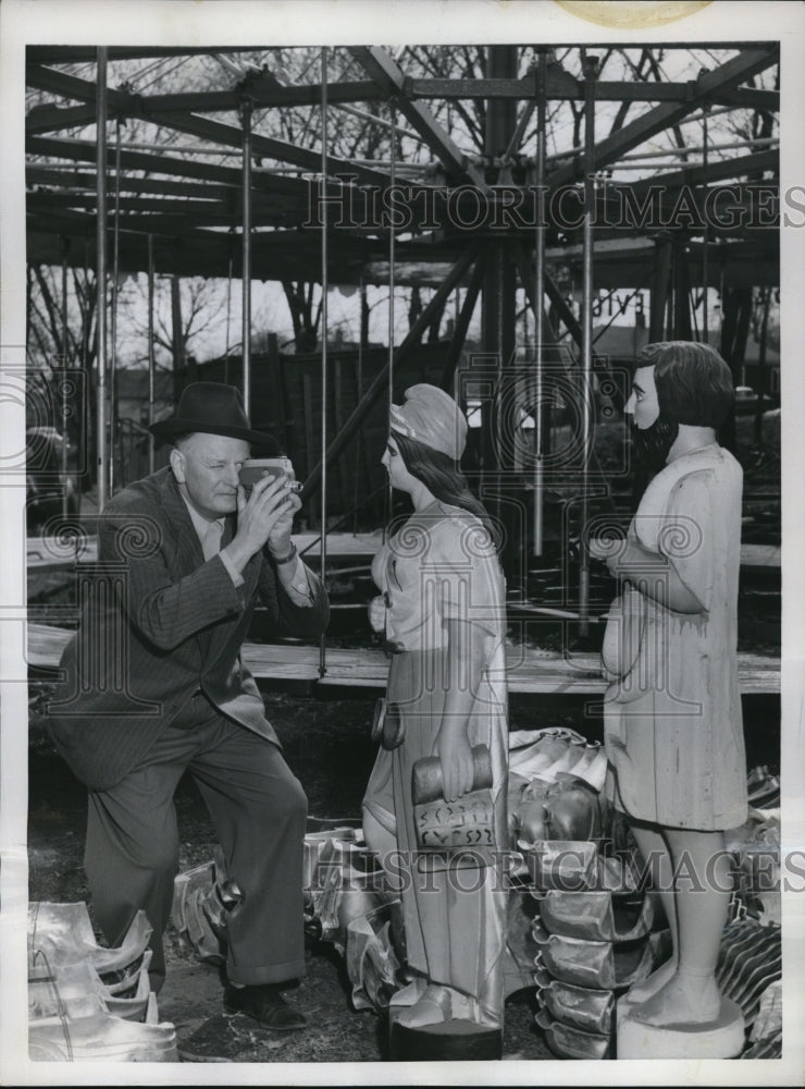 Load image into Gallery viewer, 1954 Press Photo Paul Parker taking pictures on a hand carved statues

