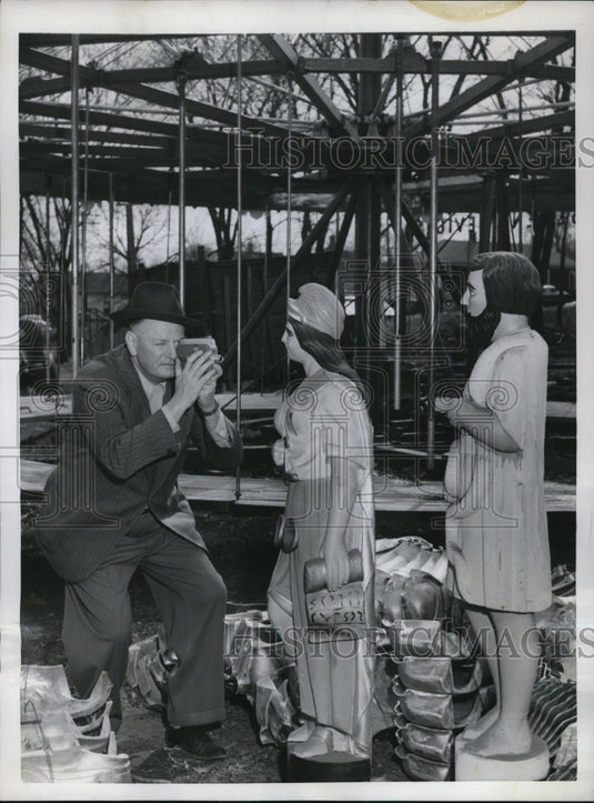 1954 Press Photo Paul Parker taking pictures on a hand carved statues