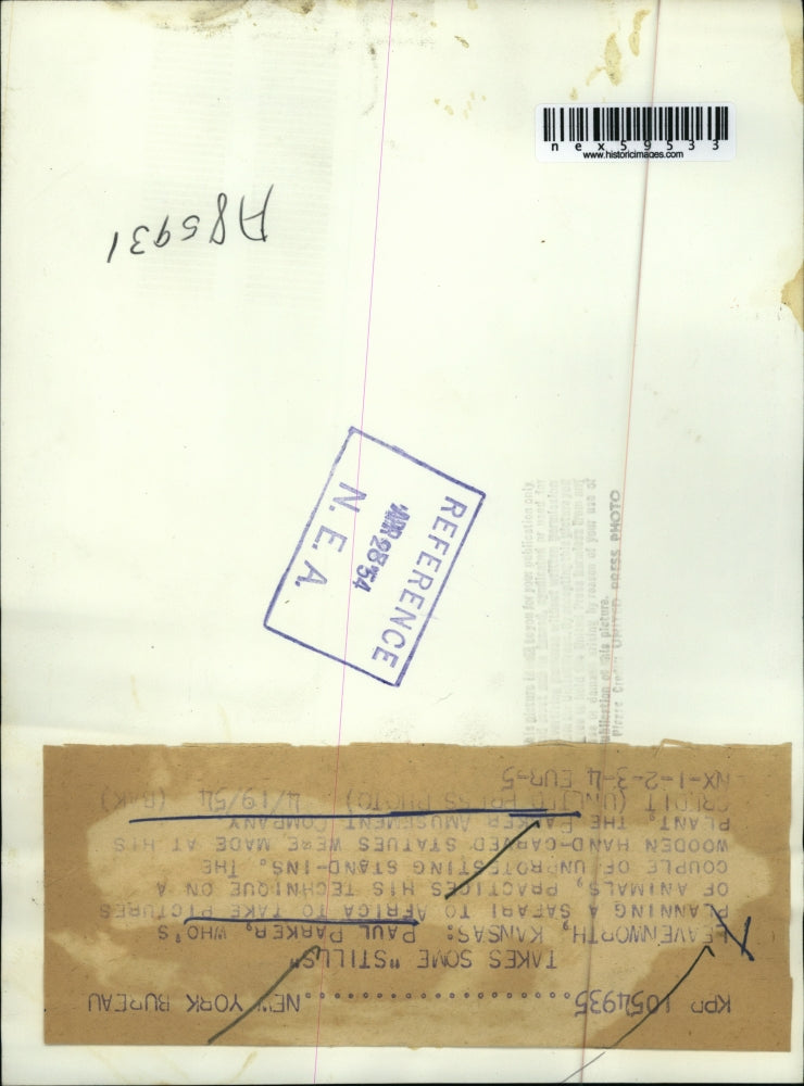 1954 Press Photo Paul Parker taking pictures on a hand carved statues