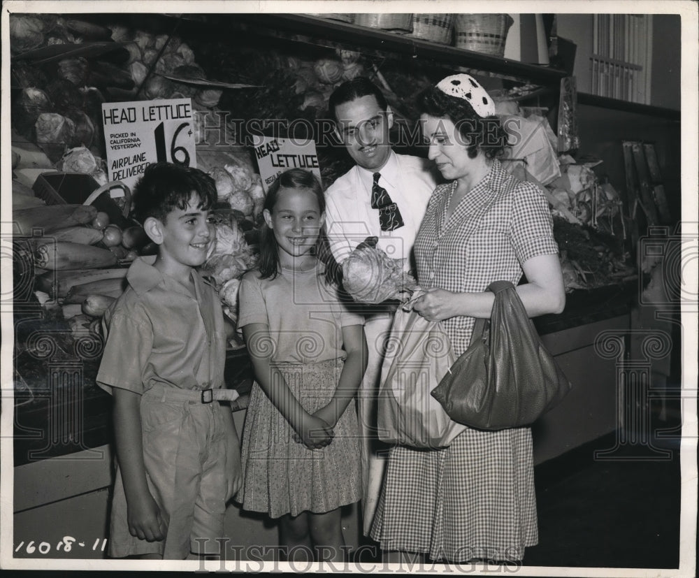 1944 Press Photo A mom & kids at a grocery market checks lettuce