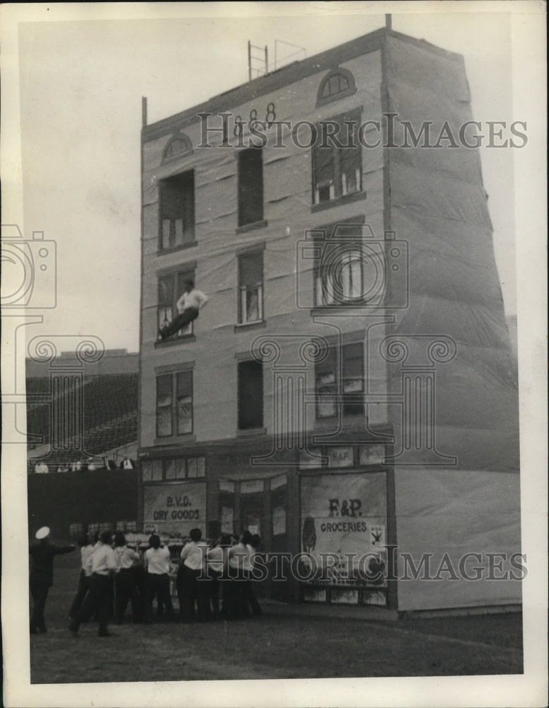1933 Press Photo Fireman jumps into life net as building supposedly is on fire