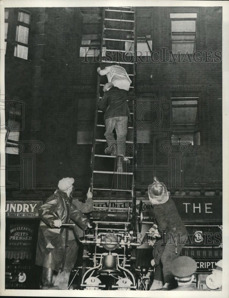 1932 Press Photo Cleveland Ohio firemen rescue woman from buring apartment