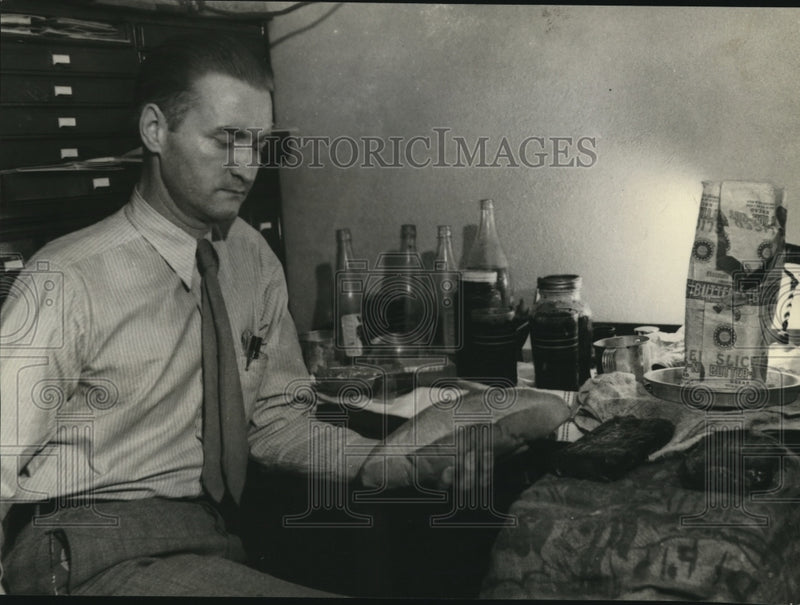 Load image into Gallery viewer, 1934 Press Photo Deputy Sheriff Guiney holding food &amp; other articles on table
