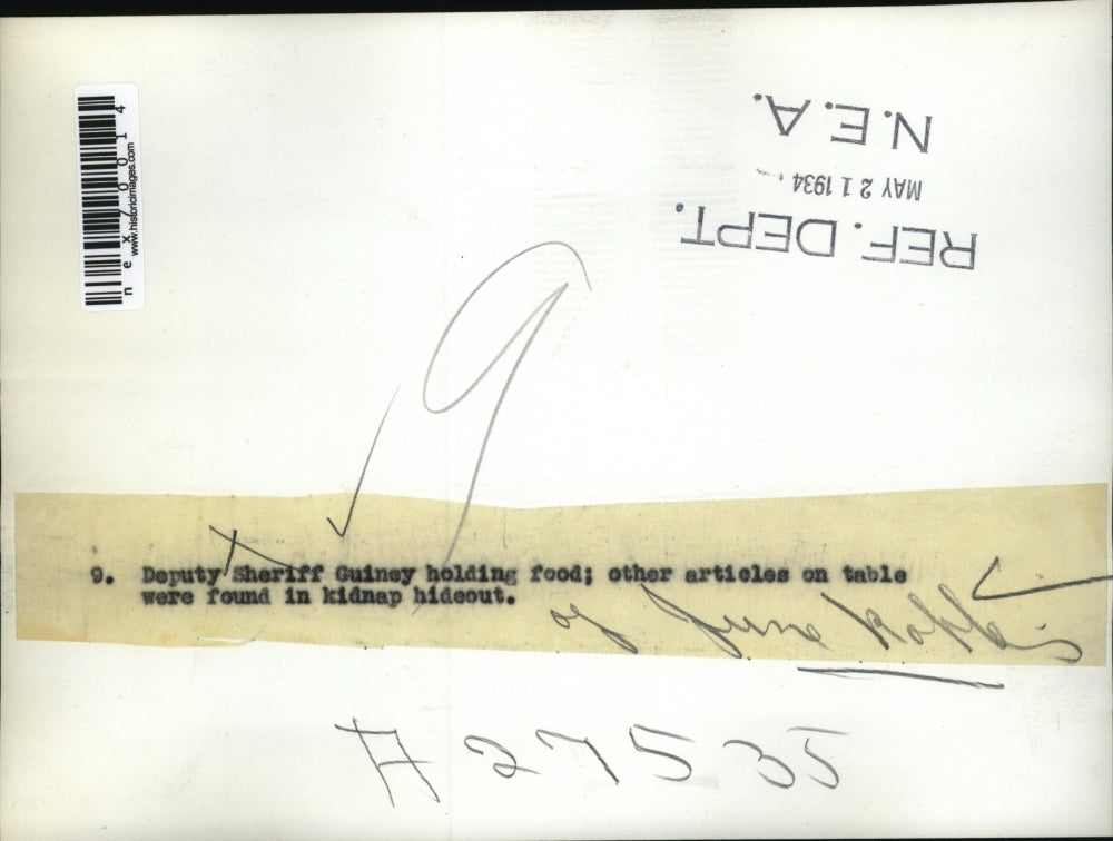 1934 Press Photo Deputy Sheriff Guiney holding food & other articles on table