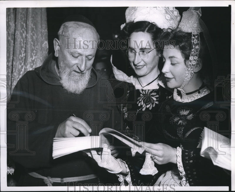 Load image into Gallery viewer, 1954 Press Photo Paris Author Father Tvon signs book for Soiion, Mailleson
