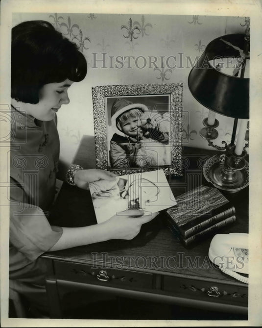 1961 Press Photo A mother tries to save mementos with new type color prints
