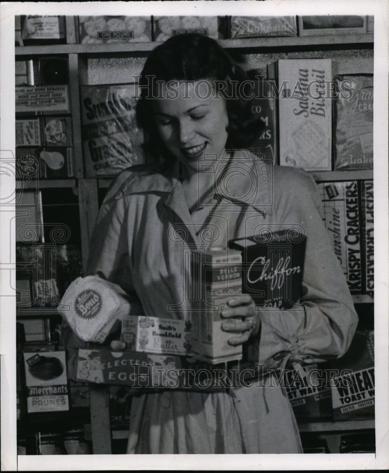 Load image into Gallery viewer, 1947 Press Photo Cleveland Frances Kositzky at grocers with milk, butter &amp; soap
