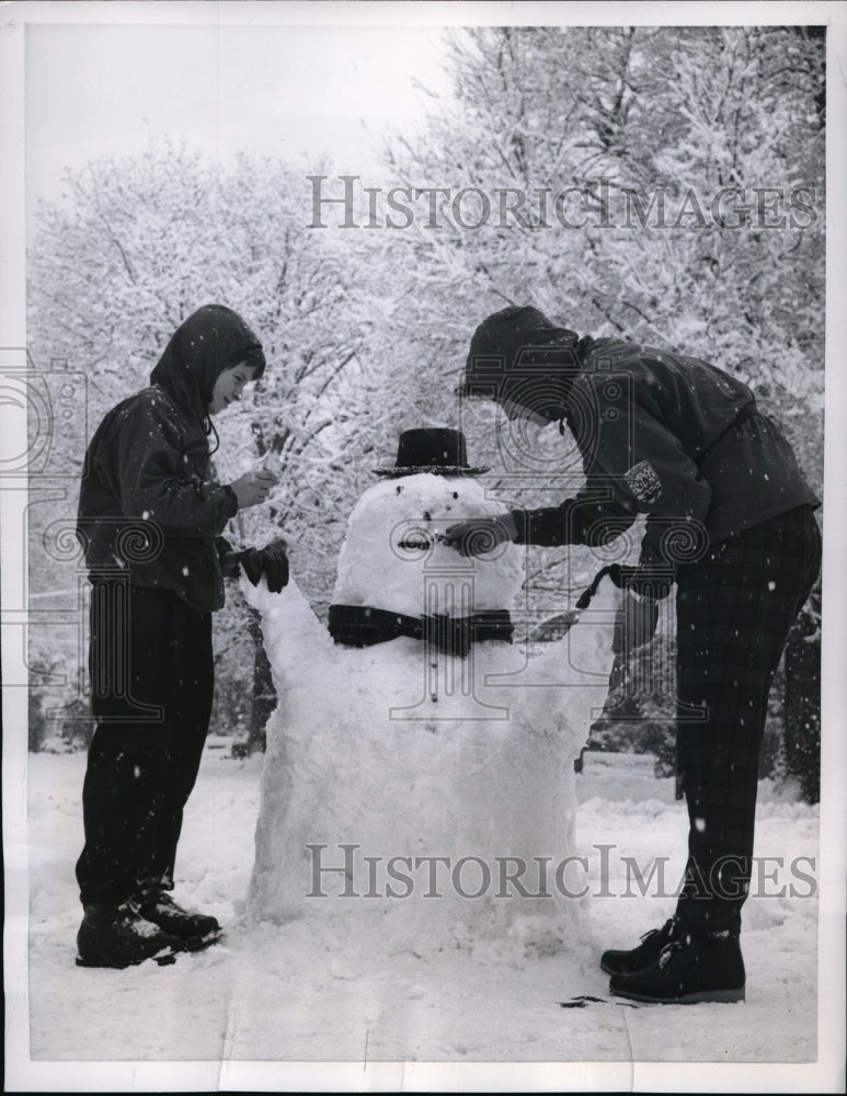 Load image into Gallery viewer, 1956 Press Photo Girl Lights Cigarette for Snowman in Milan Park Italy
